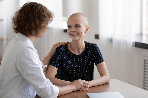 Hopeful young sick woman sit at desk listen to doctor